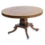 A Regency rosewood and brass inlaid breakfast table, the circular top decorated with scrolls, leaves