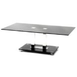 A modern smoked glass and chrome plated coffee table, with a rectangular top on twin square