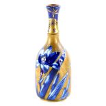 A Doulton ceramic bottle shaped vase, decorated with flowers in under glazed blue, with over