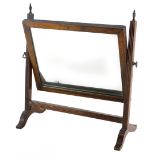 A mahogany swing frame dressing table mirror, the rectangular plate on reeded supports, headed by