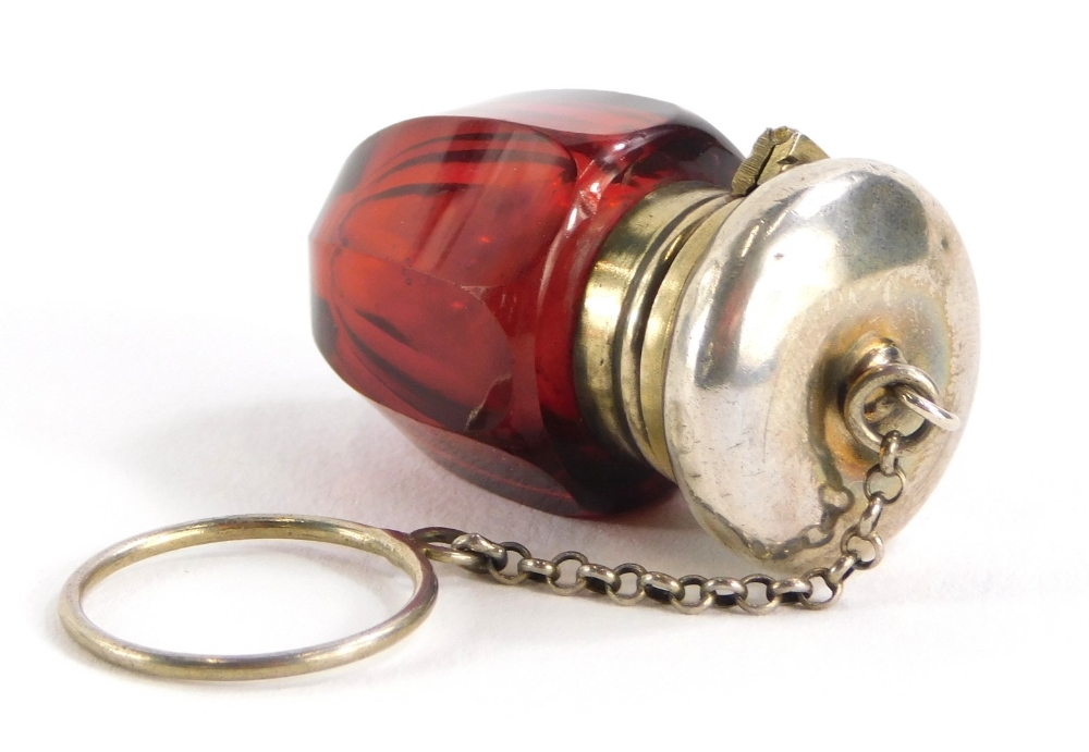 A cranberry glass vinaigrette, the stopper cast with scrolls, leaves, etc., with chain handle and