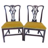 A pair of George III mahogany side chairs, in the manner of Thomas Chippendale, with a carved