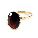 A 9ct gold garnet set dress ring, with oval cut garnet, in a raised claw setting, with pierced