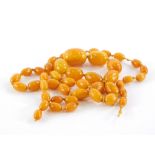 An imitation butterscotch amber necklace, with various graduated beads, approximately 80cm long