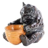 A Royal Doulton stoneware salt, modelled in the form of bear or bear cub, holding a basket in the