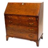 An early 19thC oak bureau, the mahogany crossbanded fall enclosing a fitted interior, above four