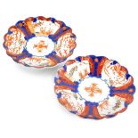 A pair of Japanese Imari porcelain chargers, each with a shaped border and decorated in blue, red