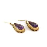 A pair of 9ct gold amethyst drop earrings, the teardrop cut amethyst in a raised setting with rope