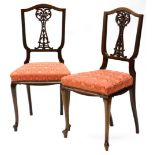 A pair of Edwardian mahogany salon chairs, each with a pierced carved splat, a padded seat on