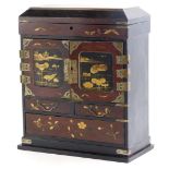 An early 20thC Japanese lacquered jewellery cabinet, with a hinged lid above two doors, each with