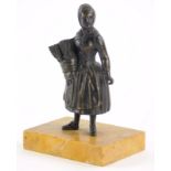 A 19thC continental bronze match holder, modelled in the form of a lady, on a yellow marble base,