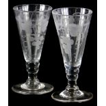 A pair of late 18th/early 19thC glass ale flutes, with engraved decoration of grapes, wheat, etc.,