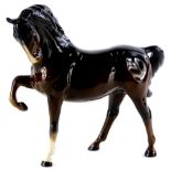 A Beswick brown glazed horse, with raised leg, 19cm high.