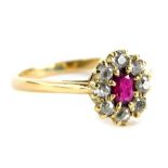 A ruby and diamond cluster ring, with over cut ruby in claw setting, surrounded by round brilliant