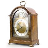 An Elliott mantel clock, in a walnut case, the arched dial stamped Tempus Fugit Made In England,
