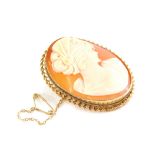 A 9ct gold framed shell cameo brooch, the oval cameo depicting a lady in dress with elaborate