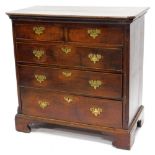 A George III oak chest of drawers, the rectangular top, moulded edge and canted corners above a