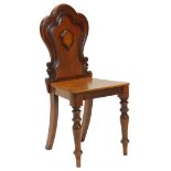 A Victorian mahogany hall chair, the shaped back with a central cartouche, on turned tapering legs.