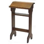 An oak prayer stand, with slope top, on end supports with shelf and stretcher, 82cm high, 47cm