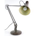 A brown Anglepoise lamp, on a circular foot.