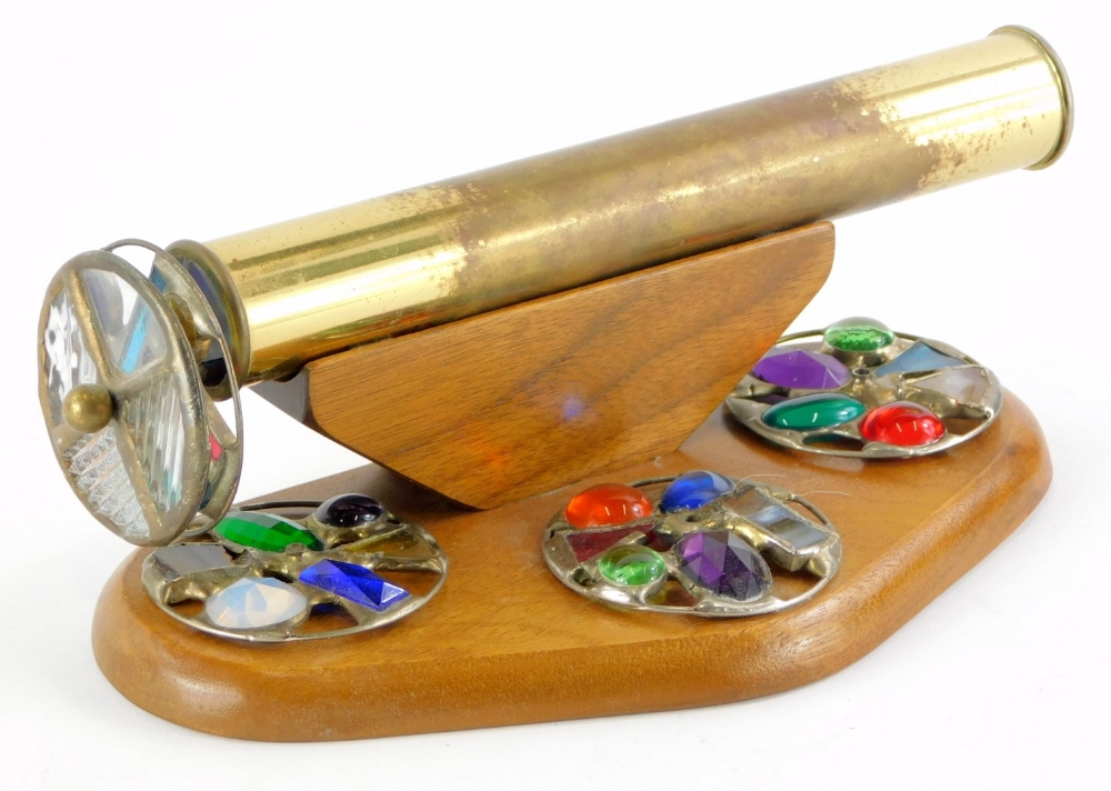 An unusual brass and wooden kaleidoscope, with five coloured and stained glass roundels, 23cm long.