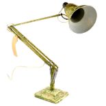 A cream Anglepoise lamp, with green camouflage decoration.