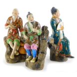 Three Chinese porcelain models, each in the form of a seated gentleman, 16cm high.