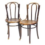 A pair of Mundus bentwood chairs, each with a solid seat on splayed legs.