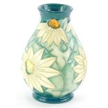 A Moorcroft pottery baluster vase, decorated with white flowers, with pale green leaves, on a