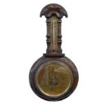 A late 19thC aneroid barometer, in a carved oak case (AF), 47cm long.