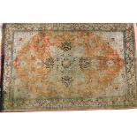 A Persian rug, with central elaborate medallion, decorated with leaves and flowerheads, on a pale