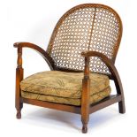 A 1920s beech and caned open armchair, with a loose cushion, on turned legs.