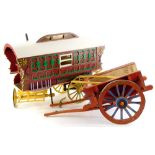 A painted model of a Gypsy or Romany caravan, with spoked wheels, 45cm long, and a scale model of