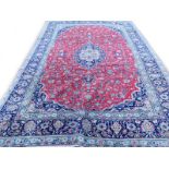 A Persian Kashan carpet, with a design of medallions on a red ground with one wide border and