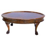 A burr walnut coffee table, the oval top on cabriole legs with paw feet, 36cm high, the top 60cm x