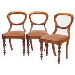 A set of three Victorian mahogany balloon back chairs, each with part leaf carved back, drop in seat