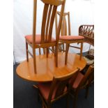 An oval teak extending dining table and six similar chairs. The upholstery in this lot does not
