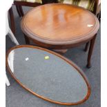 A circular mahogany coffee table on slender tapering legs, with pad feet and an oak oval wall