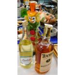 A Murano glass figure of a clown, bottle of Teachers Scotch Whisky, bottle of Lambrini. (3)