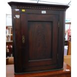 A mahogany hanging corner cabinet, with dental cornice and single panelled figured mahogany door.