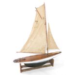 A wooden scale model of a single masted yacht, fully rigged, on a stand, 138cm wide.