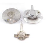 A VW hub cap, three spoke propeller cap, and a Morris Minor car badge. (3)