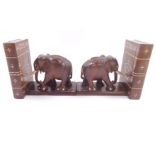 A pair of Ceylon early 20thC hardwood and ivory inlaid bookends, modelled as books fronted by elepha