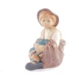 A Nadal matt pottery figure of a boy, modelled seated, printed marks, 22.5cm high.