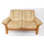 An Ekornes Stressless light oak two seater sofa, upholstered in tan leather, 148cm wide. (AF)