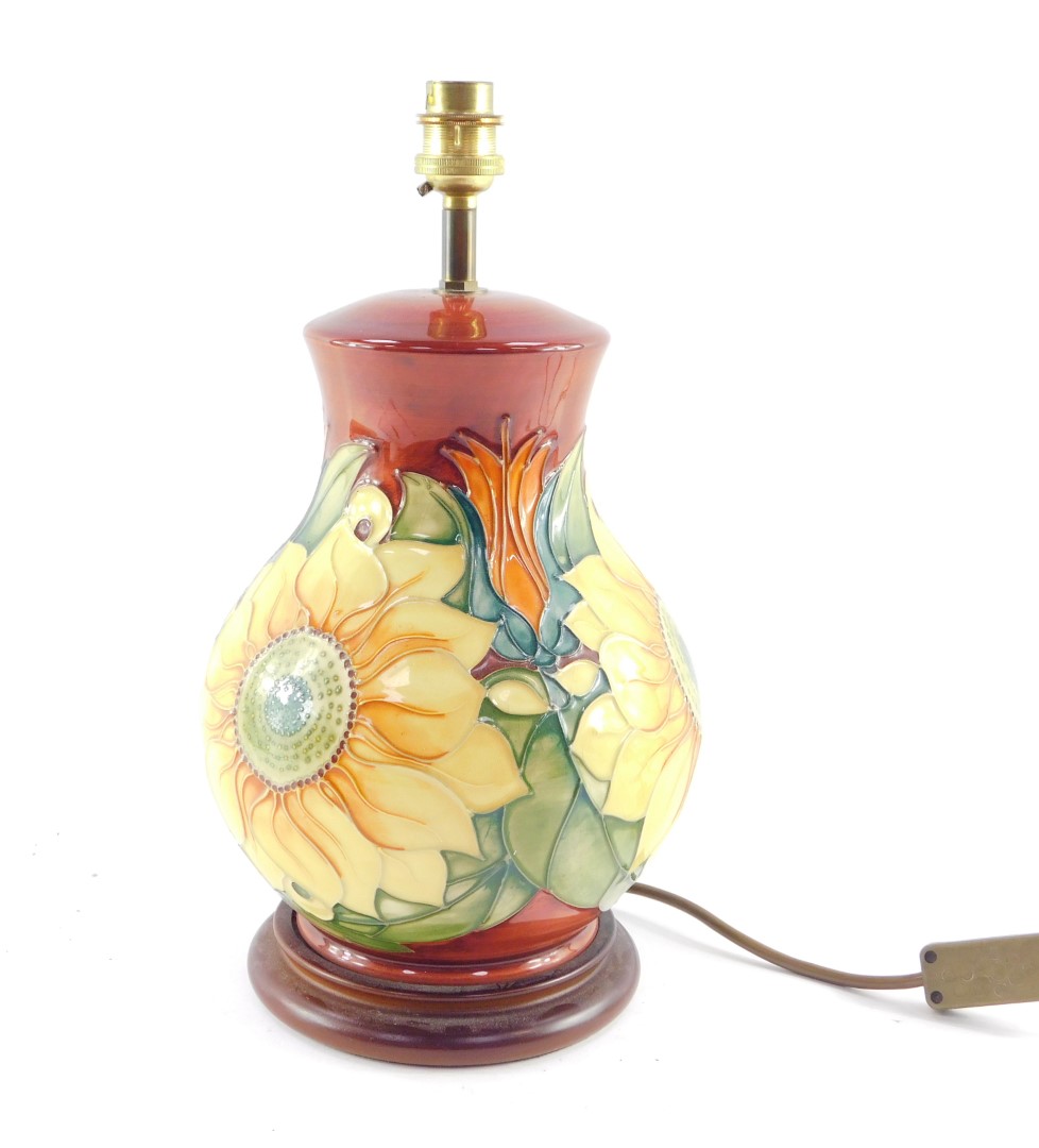 A Moorcroft pottery table lamp decorated in the Inca Sunflower pattern, of baluster form, against a