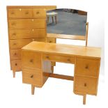 A mid century Georgian style light oak chest, of two short over five long drawers, raised on taperin