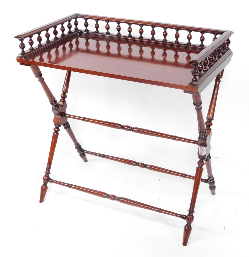 A mahogany butler's tray top table, with a three sided gallery raised on X frame supports, united by