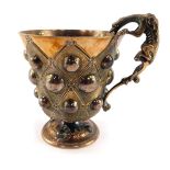 A Victorian silver cup, of pedestal form with a cast dragon handle, decorated with textured floral l