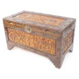 A Chinese 20thC camphorwood chest, pale and dark stained, carved with panels of dragons and ho ho bi